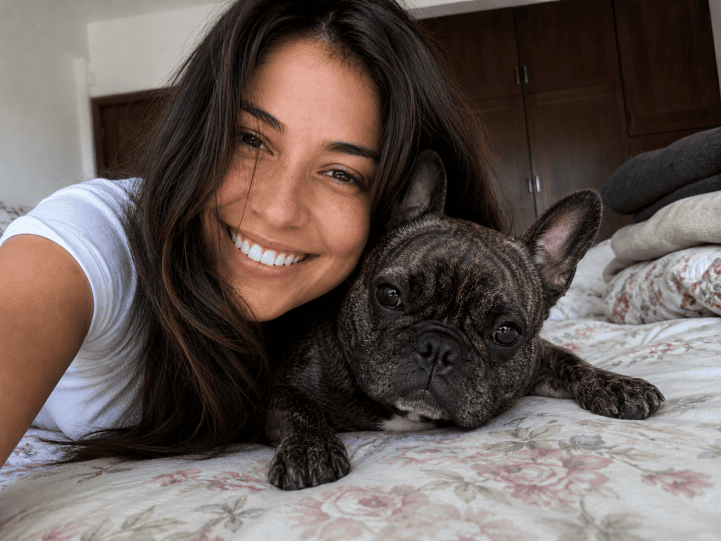 woman cuddles her frenchie and needs dog gadgets for him