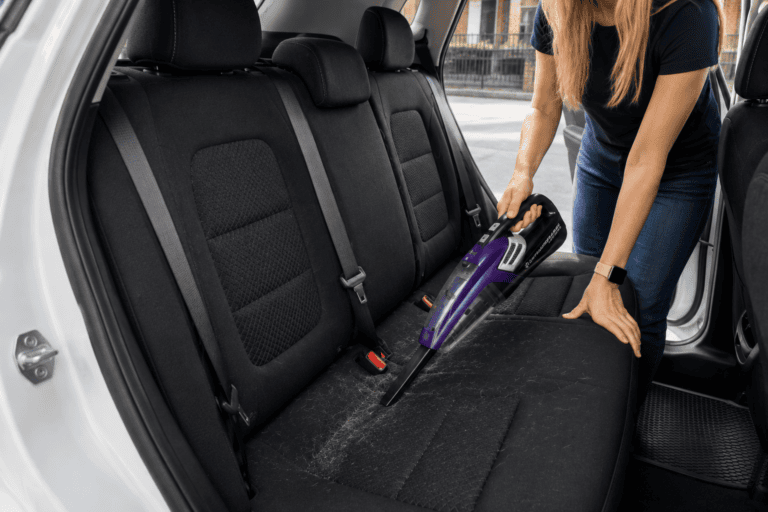 backseat of SUV using the car vacuum for dog hair